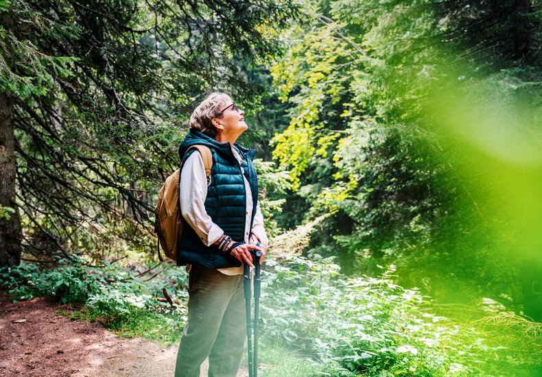 Frau mit Wanderstöcken im Wald