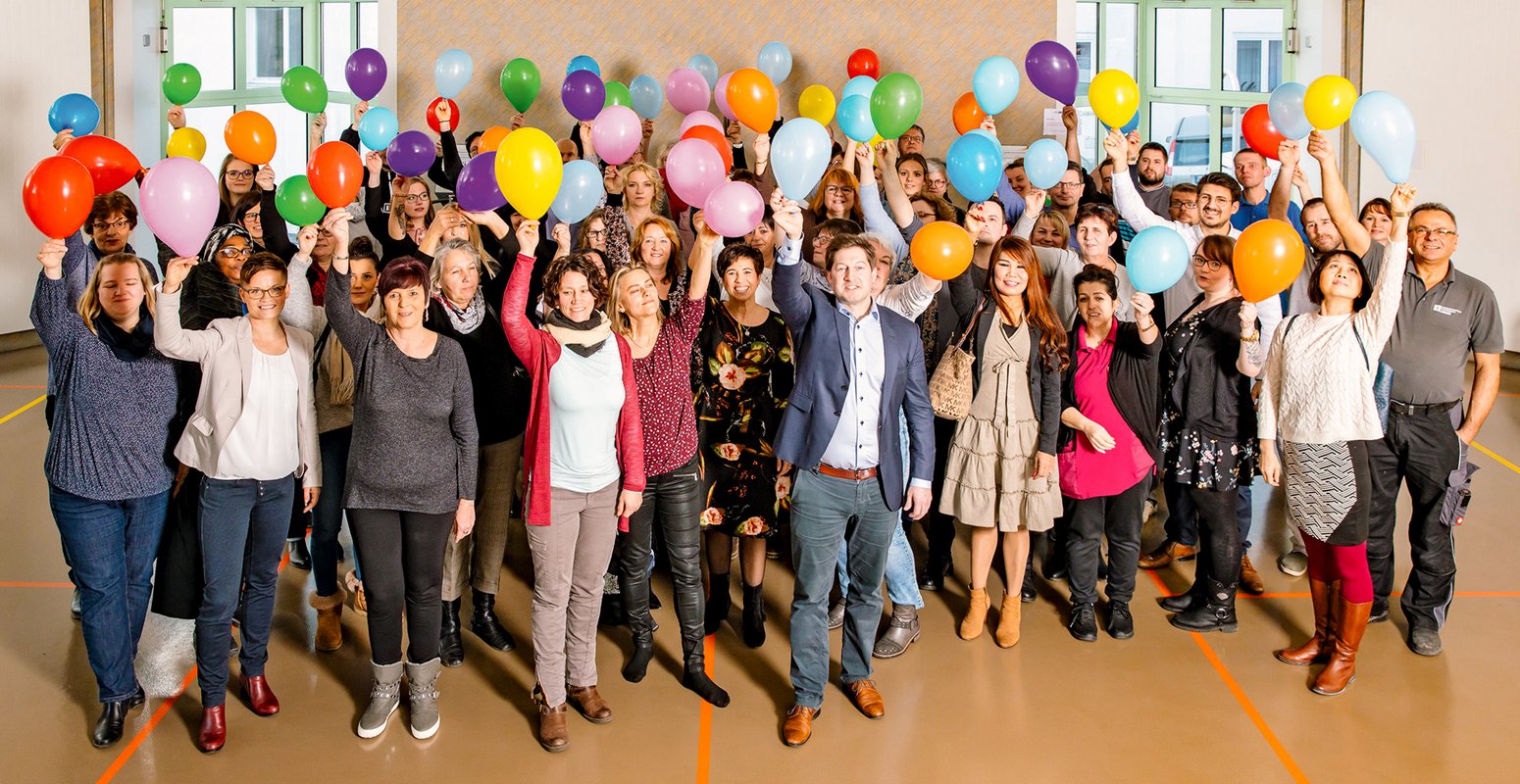 Personal mit bunten Ballons in den Händen