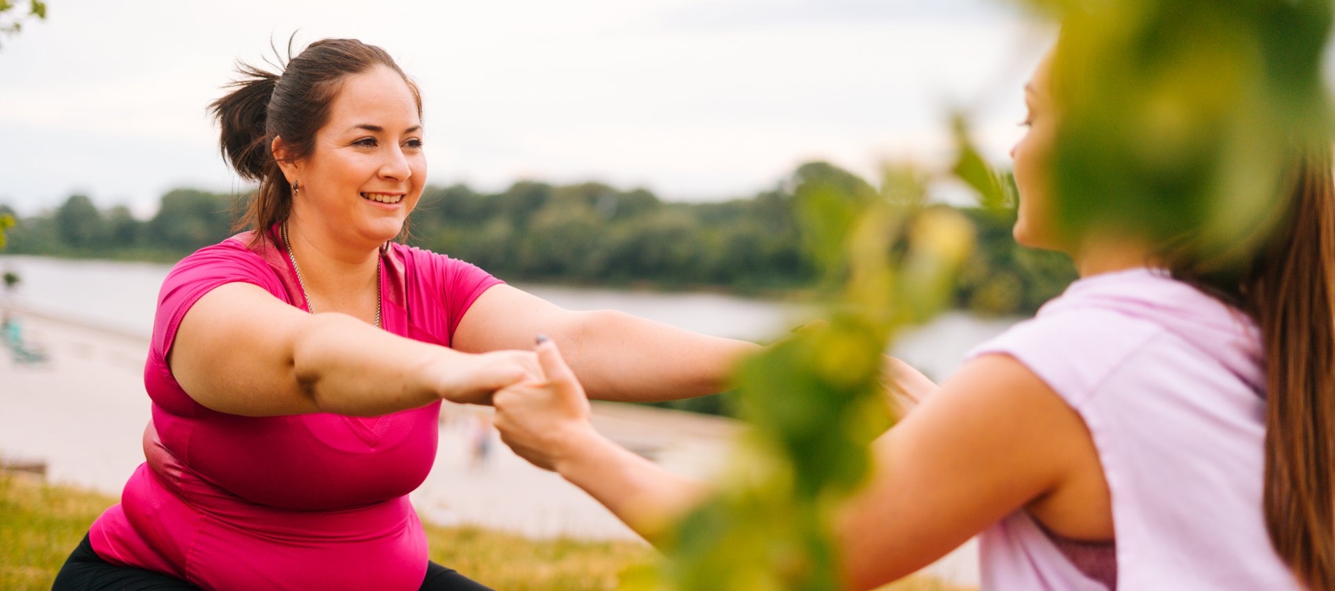 Zwei Frauen halten sich die Hände im Freien